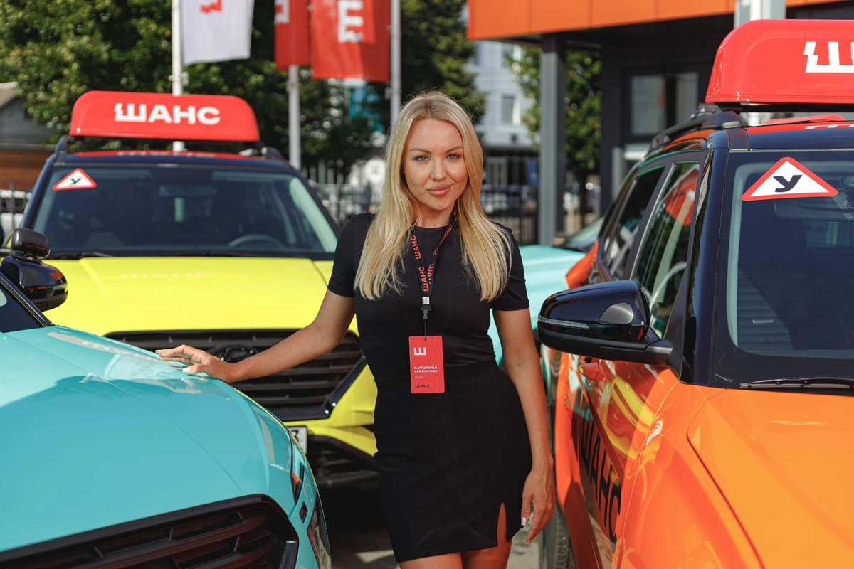 Сотрудница автошколы «Шанс» у ряда учебных автомобилей